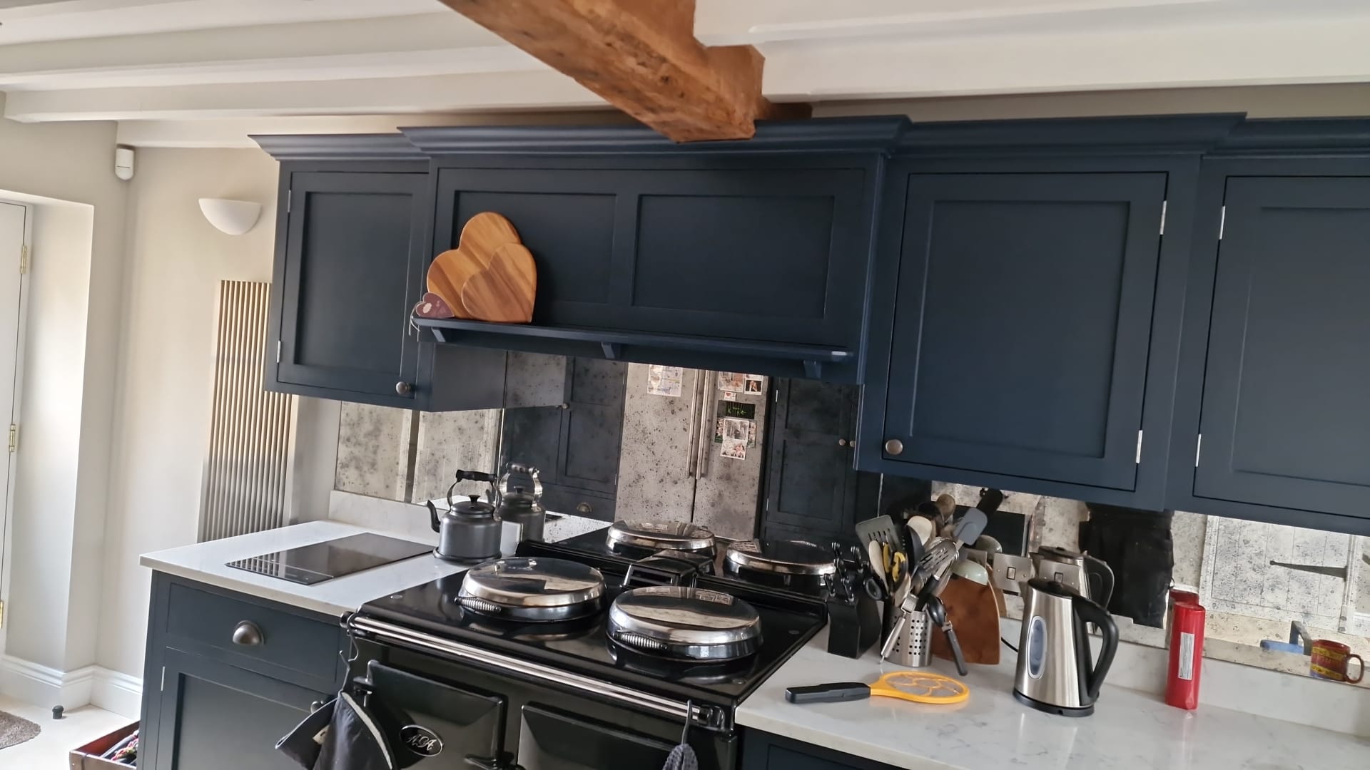 Exposed beam, range cooker and dark cabinets in a kitchen we finished