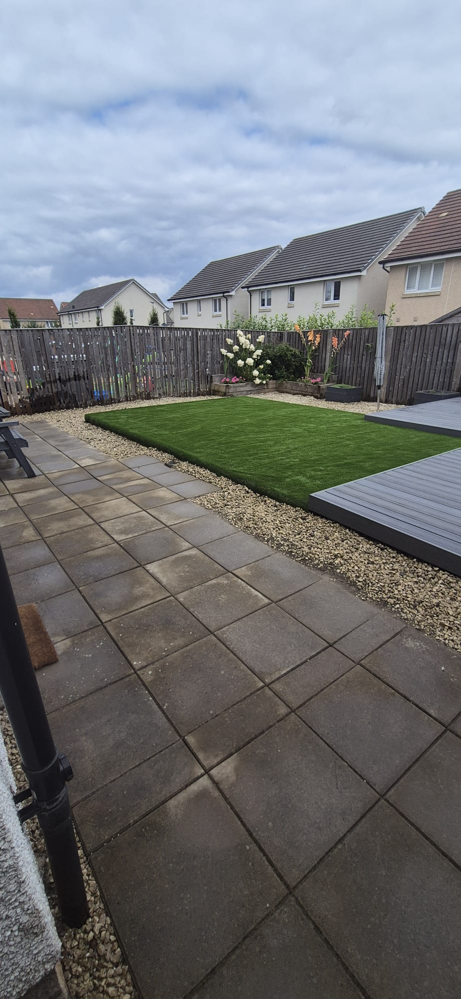 Patio, artificial grass and composite decking in a finished garden