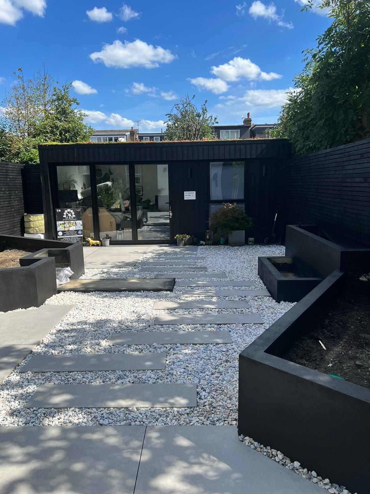 Finished garden room path with white gravel, porcelain stepping stones and raised beds