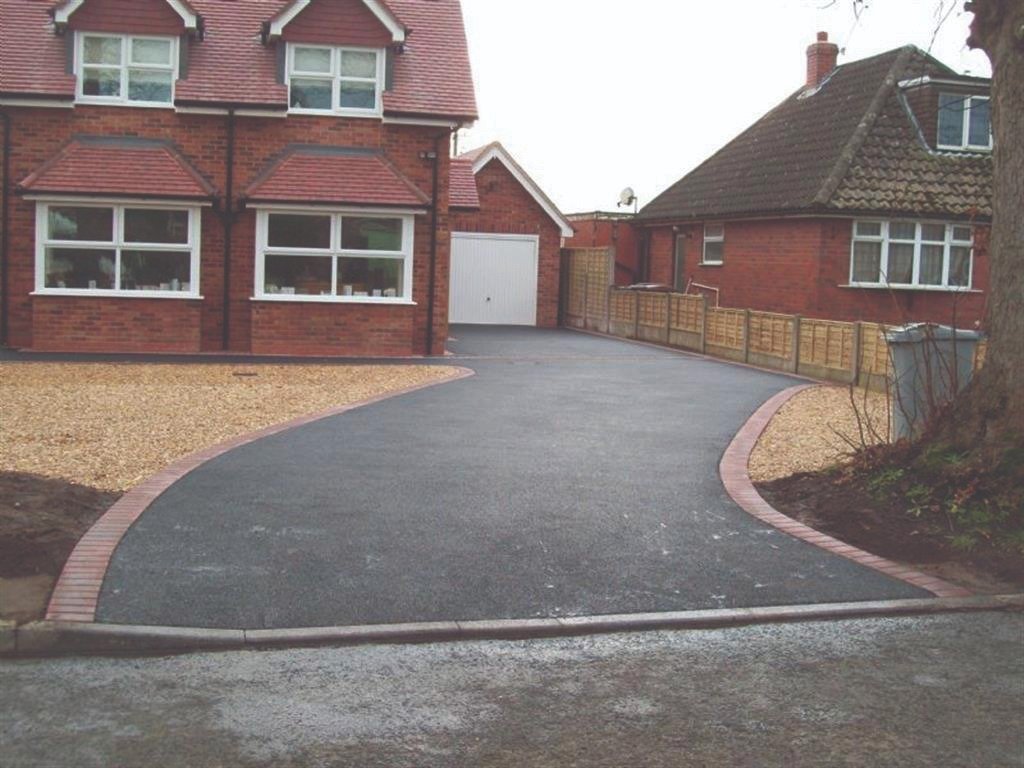 Sweeping tarmac driveway finished with red block edging