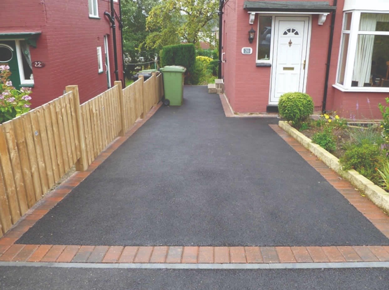 Finished tarmac driveway beside a timber boundary fence