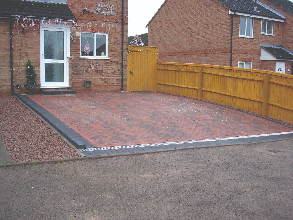 Finished block paved front drive running alongside a timber fence