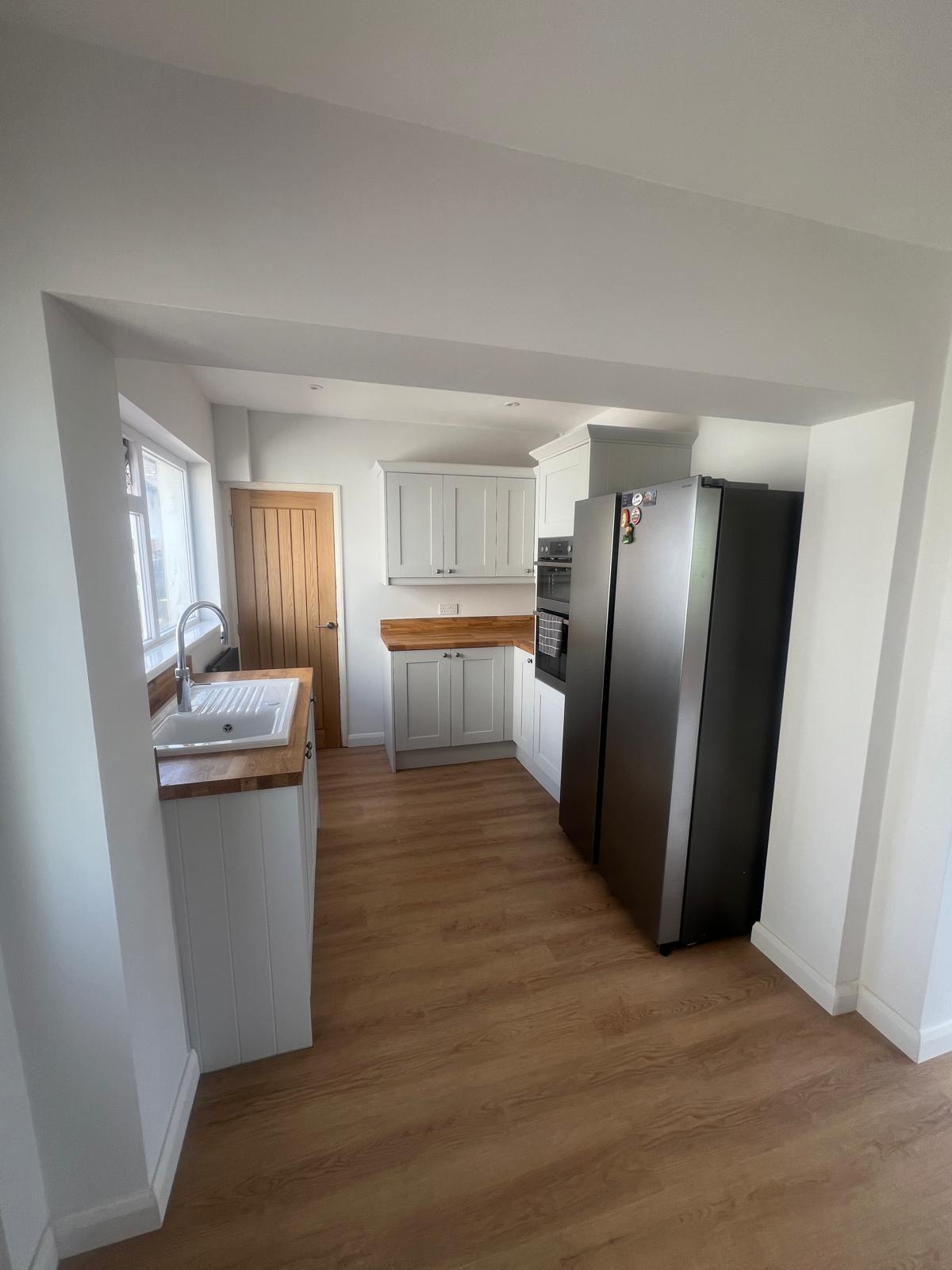 Galley kitchen with shaker units, oak worktops and new flooring fitted by Truscon