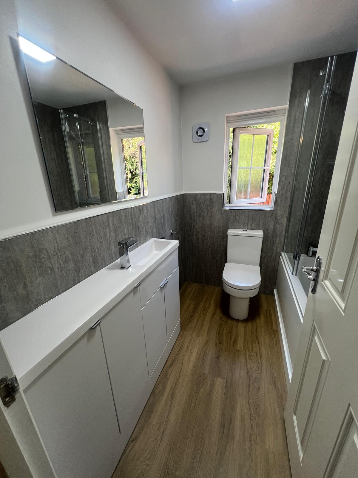 Bathroom vanity unit, toilet and grey wall panelling fitted by Truscon