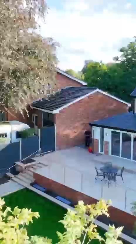 Showreel stills of finished gardens: porcelain patios with lit steps, planting and an aerial view of a completed garden