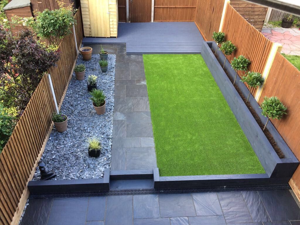 Finished garden with dark paving, artificial lawn, gravel and raised planting beds