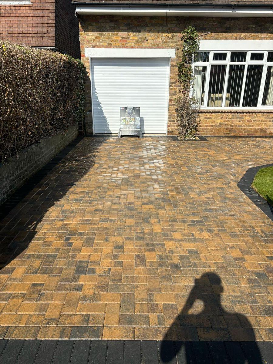 Gold and brown block paving driveway with a dark border