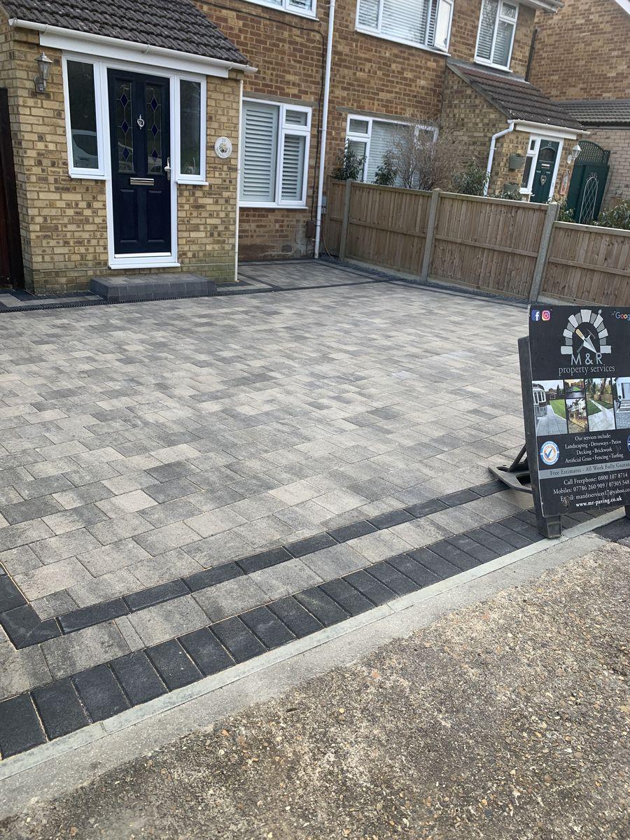 Block paving driveway with a dark border and an M&R signboard