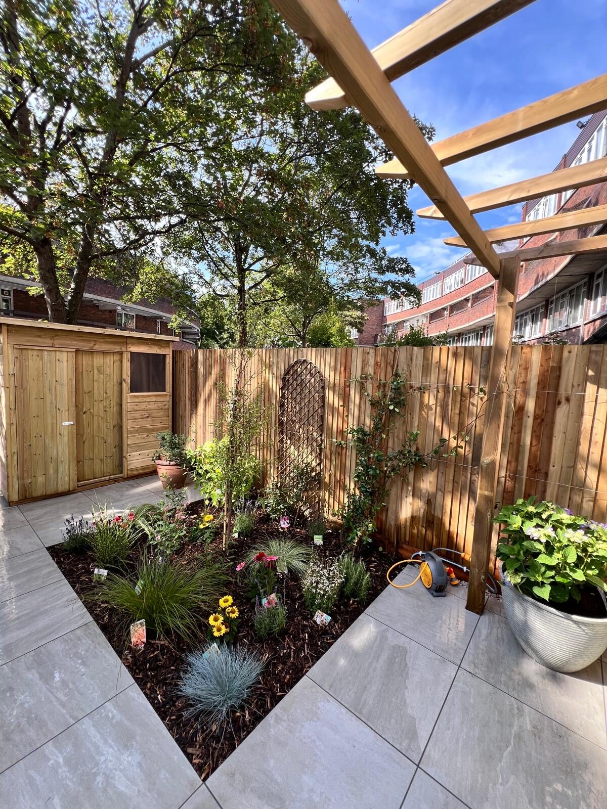 Finished courtyard garden with porcelain paving and a raised border