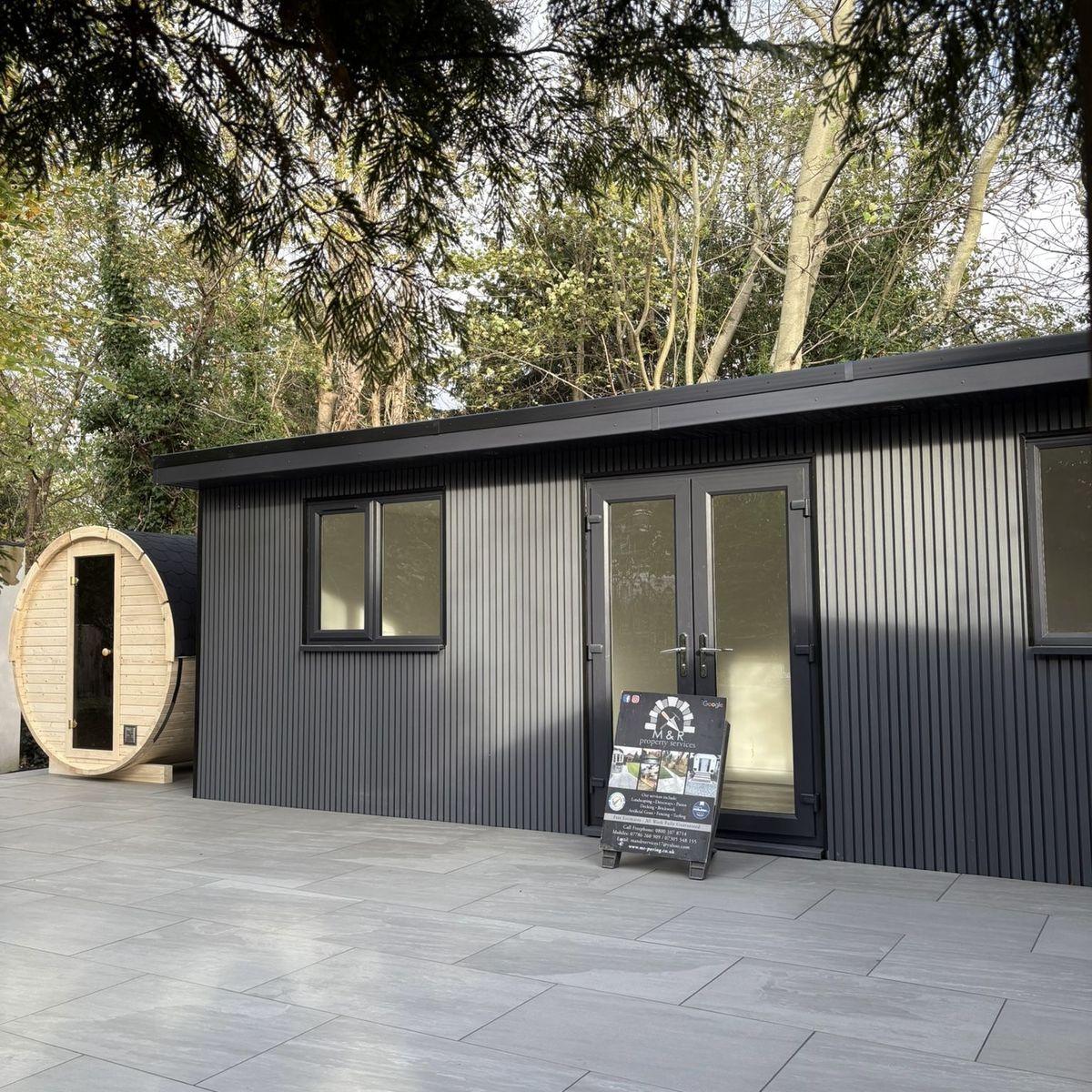 Garden room with porcelain paving and a barrel sauna